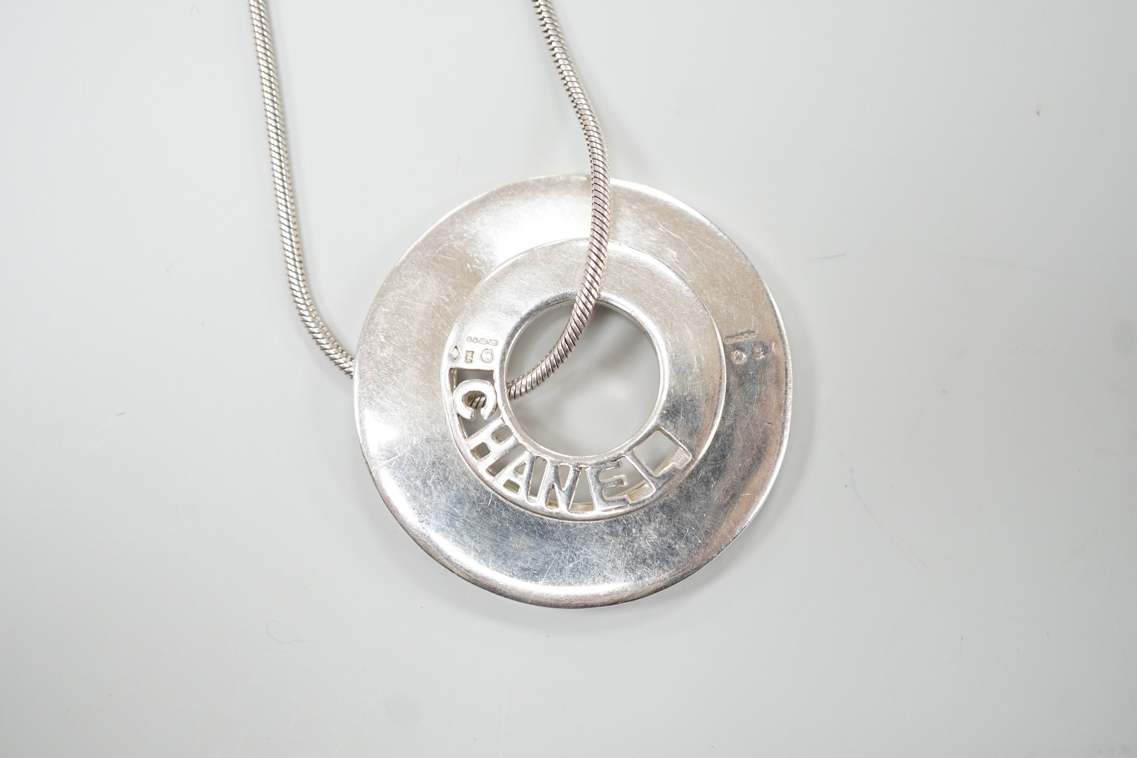 A French silver Chanel graduated double disc pendant necklace, on snake link chain, London import marks for 2001, diameter 44mm, 46.8 grams.